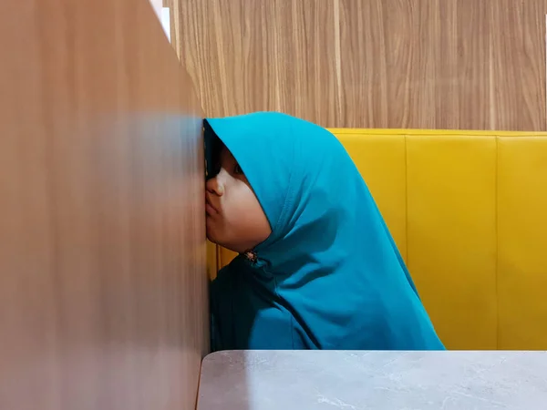 Μικρός Ασιάτης Μουσουλμάνος Κοριτσάκι Φαινόταν Δυσαρεστημένος Ενώ Κάθεται Στο Καφέ — Φωτογραφία Αρχείου