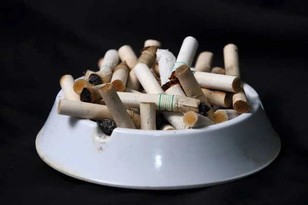 Högen Med Cigarettfimpar Vit Askkopp Mörk Bakgrund Dåligt Rökberoende Koncept — Stockfoto