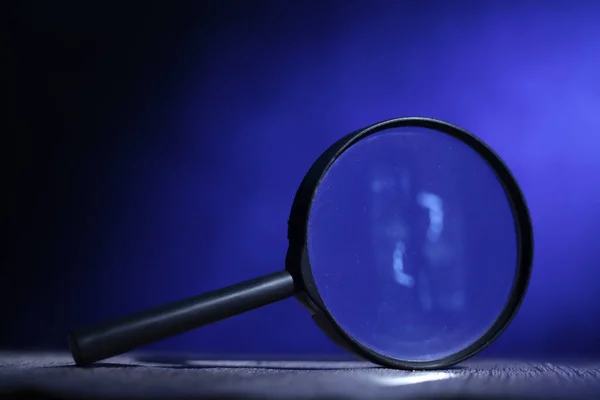 深蓝色背景的放大镜 在明亮 神秘的侦探概念下 — 图库照片