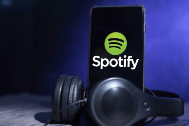 Tenggarong, Endonezya. 29 Haziran 2021. Üzerinde kulaklık, müzik uygulaması konsepti olan akıllı telefon.