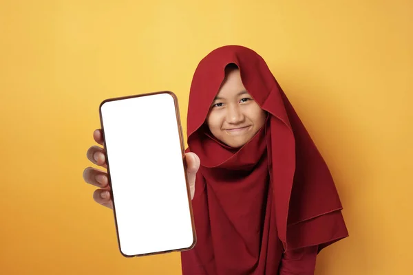 若いアジアのイスラム教徒の女性は カメラを見てヒジャーブを身に着けています 笑顔と空の空白の白いコピースペースの電話モックアップテンプレートを表示 — ストック写真