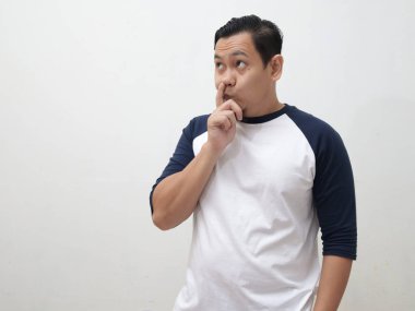 Asyalı adam aptal düşünce jestleriyle, burnunda parmağıyla yan tarafa bakıyor.