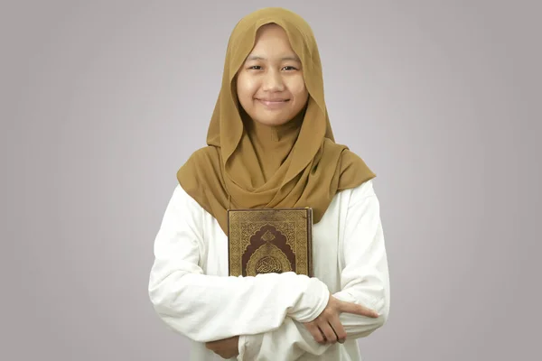 ヒジャーブを身に着けているアジアのイスラム教徒の女の子クルアーン イスラム教の聖なる本 灰色の背景を背景に — ストック写真