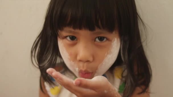 かわいいリトルアジアの赤ん坊の少女は顔の粉で遊んで 彼女の顔に白い粉を吹き飛ばし 閉じます — ストック動画