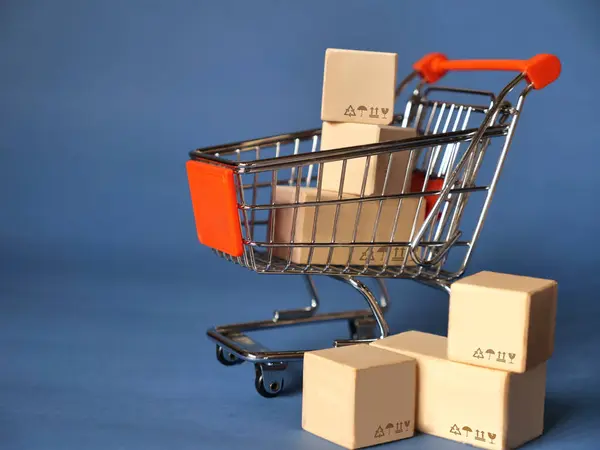 Mini shopping cart full of shipping boxes, online selling marketing ready for delivery distribution concept