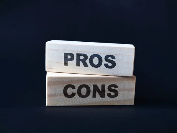 Pros and cons, text words typography written on wooden blocks, business life and self development concept