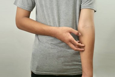 Anonim bir adam kaşınıyor, elini acıdan kaşıyor, kapat.