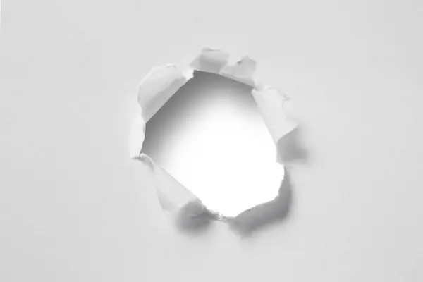 Ragged hole on ripped paper, cut out isolated white