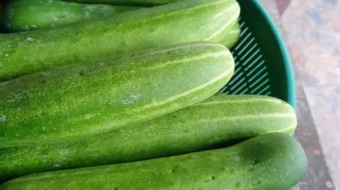 Taze yeşil salatalık sepette, sebzeler geleneksel pazarda.