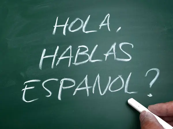 Hola hablas espanol, do you speak spanish question. Language skill concept, text written on chalkboard