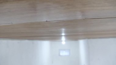 Boyacı ahşap vernik uyguluyor, fırça hareketini kapatıyor