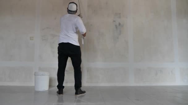 Asyalı Erkek Ressam Paten Fırçasıyla Yeni Bir Beyaz Duvar Boyuyor — Stok video