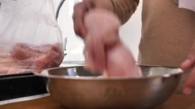 Mutfakta yemek pişirmek. Asyalı Müslüman kadın poşetinden tavuk eti çıkarıyor.