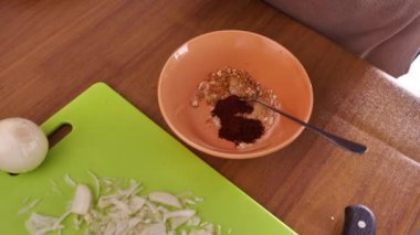 Mutfakta yemek pişirmek. Asyalı Müslüman kadın baharat ve otları karıştırıyor.
