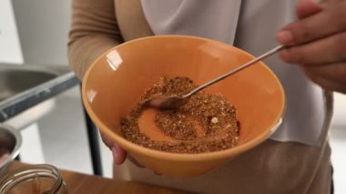 Mutfakta yemek pişirmek. Asyalı Müslüman kadın baharat ve otları karıştırıyor.