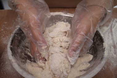 Mutfakta yemek pişirmek. Asyalı Müslüman kadın tavuk pişiriyor. Kızartmadan önce eti unla kaplıyor.