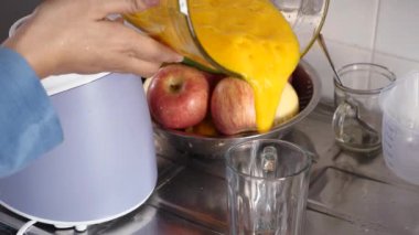 Asyalı Müslüman kadın taze mango suyu yapıyor.