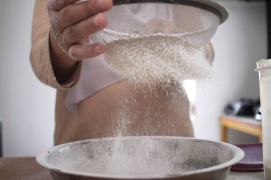 Mutfakta yemek pişirmek. Baharatlı tavuk ya da ekmek pişirmek için un toplayan Asyalı Müslüman kadın.