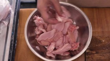 Mutfakta yemek pişirmek. Tavuk etini ince ince doğramak, pişirmeye hazır, yüksek açılı manzara.