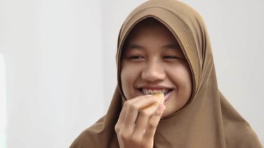 Diş teli takan Asyalı Müslüman kadının portakal, taze meyve ve yüz ifadesi yediği yakın plan.