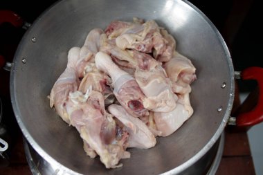 Tavada taze kesilmiş çiğ tavuk eti pişmeye hazır.