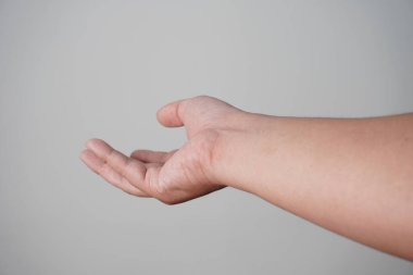 Erkek kişi el hareketi yapar, yardım ya da bağış ister, gri arka plan üzerinden.