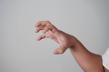Erkek insan pençeli zombi misali elini uzatıyor, bir şeye tutunuyor, gri arka planda.