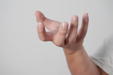 Erkek insan, elle kavrama pozisyonunda, gri arka planda, görünmeyen boş bir avuç içi tutuyor.