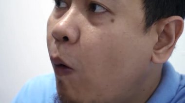 Asyalı bir adamın üzüm meyvesi yiyip sağlıklı bir şeyler yediği yakın plan.