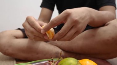 Kimliği belirsiz bir adamın portakal yediği, sağlıklı atıştırmalıklar.