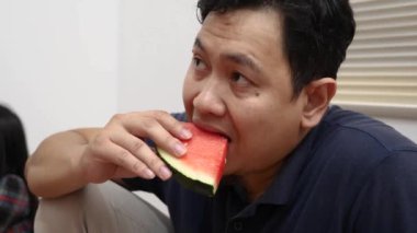 Karpuz meyvesi yiyen Asyalı adama yakın çekim, sağlıklı atıştırmalık.