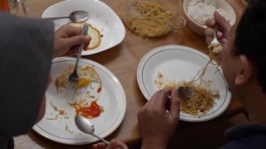 Asyalı çift, karı koca evde yemek yiyorlar.