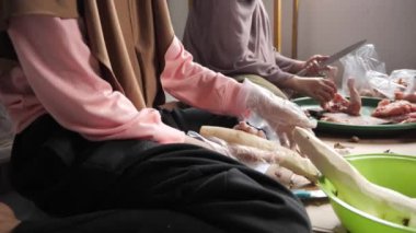 Endonezyalı Müslüman kadın kızıyla mutfakta yemek hazırlıyor, geleneksel otantik Asya yemekleri pişiriyor, doğal ışık.