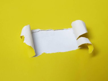 Sarı kağıtta yırtık bir delik, kıvrık kenarlı beyaz bir arka plan.