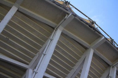 Eski bir stadyum binasının çatısı, inşaat mimarisinin beton sütunları.