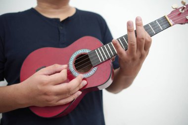 Asian man playing ukulele at home, anonymous person clipart