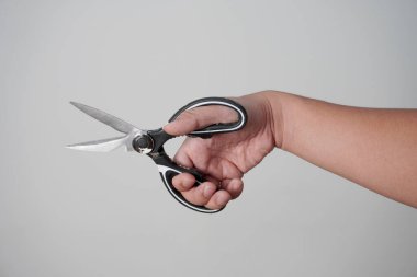 Erkek kişinin elinde makas var, beyaz üzerinde izole edilmiş.