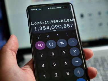 Ekranında gösterilen dijital hesap makinesi uygulamalı akıllı telefonu tutmak, muhasebe kavramı
