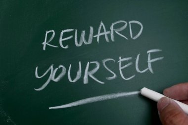 Kendini ödüllendir, tahtaya yazılmış kelime metni, motivasyon verici alıntı konsepti