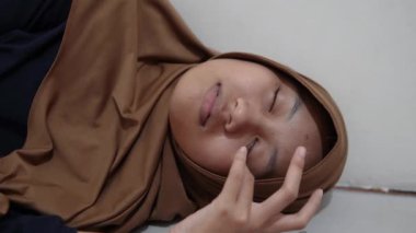 Genç Asyalı Müslüman kadın uyuyor, yatakta yatıyor. Yorucu bir günün ardından dinlen.