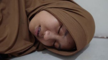 Genç Asyalı Müslüman kadın uyuyor, yatakta yatıyor. Yorucu bir günün ardından dinlen.