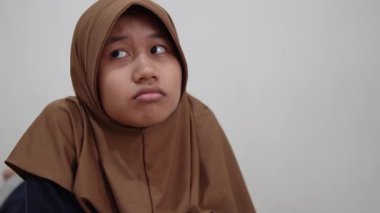 Genç Asyalı Müslüman kadın üzgün görünüyor ve hayal kırıklığı yaratan, üzgün, yalnız bir ifade düşünüyor. 