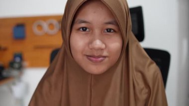 Genç Asyalı Müslüman kadın şaşırmış. Heyecanlı ifade, büyük gözler ve açık ağız. Şaşırtıcı bir jest.