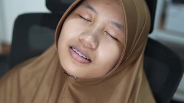 Genç Asyalı Müslüman kadın koltukta uyudu, yorgun ve çok çalışan biri.