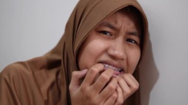 Depresyondaki Asyalı Müslüman kadın korkmuş görünüyor, kötü bir şeyden korkuyor.