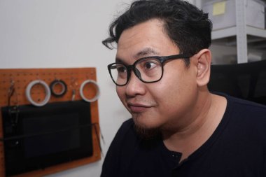 Yetişkin Asyalı adam evde bilgisayarında daktilo yazıyor, uzaktan çalışan serbest çalışan, online iş kavramı, mutlu gülümseme ifadesi.