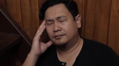 Üzgün Asyalı adam evinde merdivenlerde oturuyor, umutsuzluk hayal kırıklığı stres kaybı, hayat sorunları konsepti.