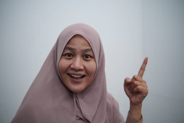 Asyalı Müslüman kadın kameraya bakarken iyi fikir ya da çözüm kavramı