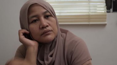 Üzgün, yalnız, Asyalı Müslüman kadın boş boş düşünüyor, hayal kırıklığı içinde, depresif biri.