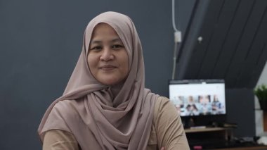 Mutlu kendinden emin Asyalı Müslüman kadın kameraya gülümsüyor, başarılı girişimci, yakın plan portresi